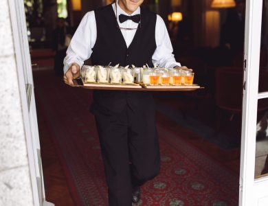 Waiter carries dish with snacks walking to the backyard