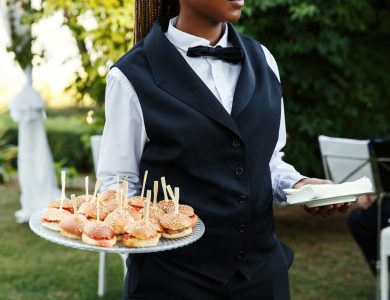 Waiter carries plate with tasty snacks