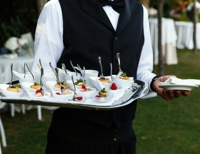 Waiter carries plate with tasty snacks